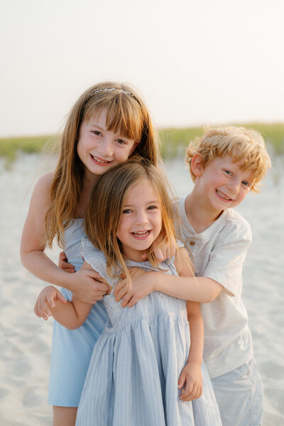 family of three siblings beach photo session in Ocean City, NJ by Magdalena Studios