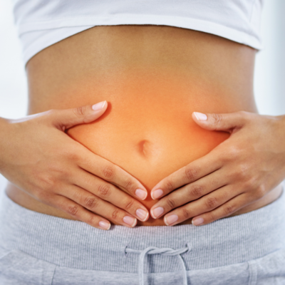 Picture of woman holding her stomach due to leaky gut issues.