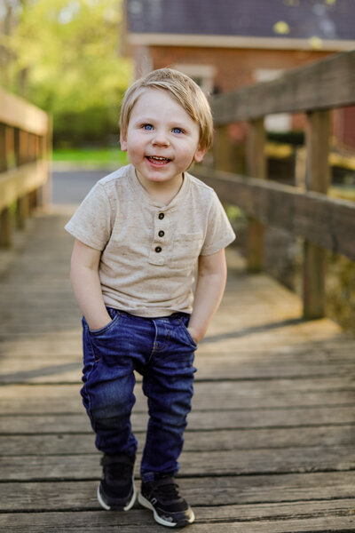 Boy posing on bridge with his hands in pockets for family photos at Lockridge park in Alburtis PA 