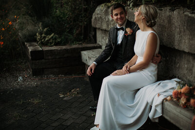 Elegant bride and groom sit and smile at each other on wedding day
