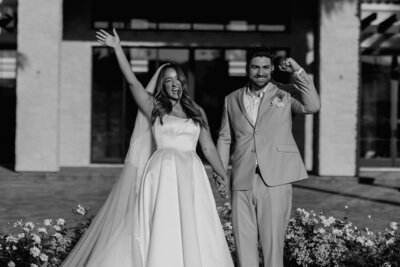 Couple with arms in the air celebrating they just got married.
