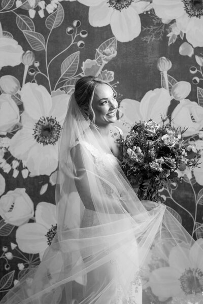 portrait of bride smiling while holding a flower bouquet