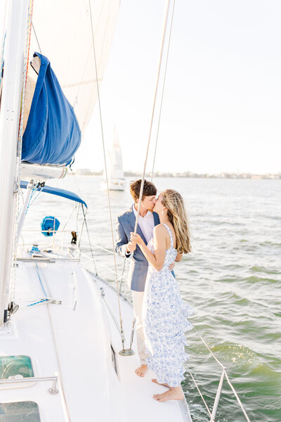 couple kissing on sailboat for their destination engagement session