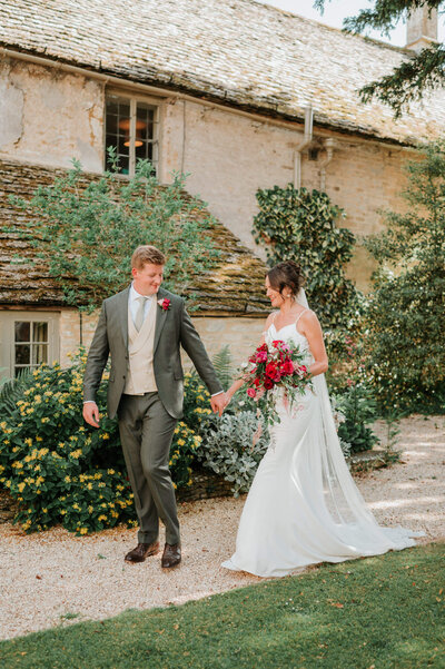 Bride and groom in the perfectly English country gardens at Caswell House, surrounded by flowers