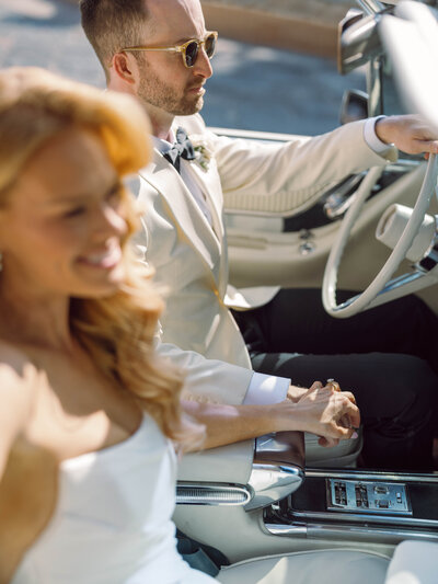 Arizona wedding photographer capturing a grand moment as a newlywed couple waves at the top of the Biltmore, with birds flying in the sky.