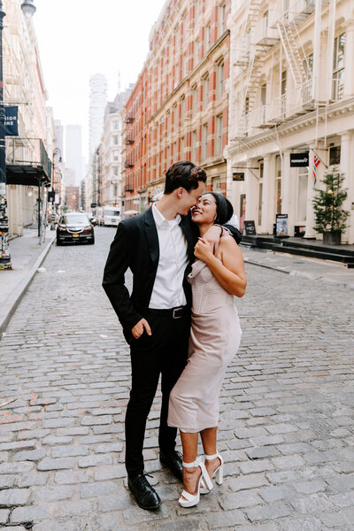 couple standing on cobblestone city road