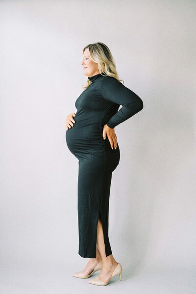 pregnant mom posing in fitted black dress