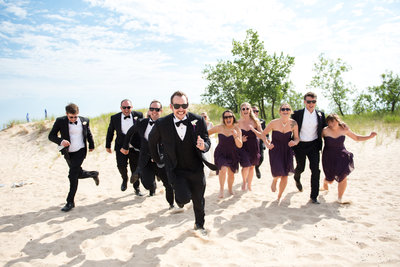 A fun wedding party photo taken at a Lake Michigan beach. West Michigan photographer
