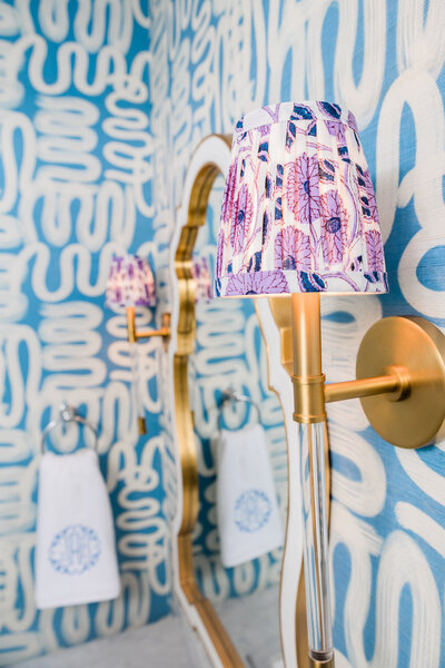 Bold patterned bathroom design with gold mirror