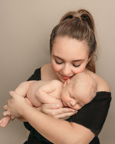 Mom holding newborn baby in portland studio with Ann Marshall Photography