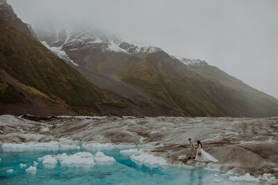 Couple walks along the glacial ice in Alaska on their elopement day.
