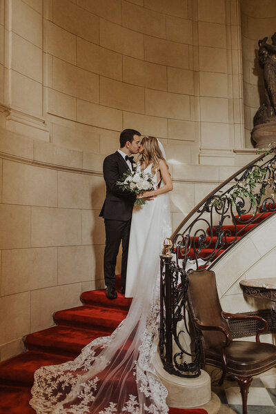 Bride and Groom kiss on stairs at Meridian House