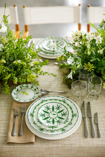 Sultan's Garden green and white china featuring illustrations of gazelles, lions, and monkeys playing beneath palm and cypress tress