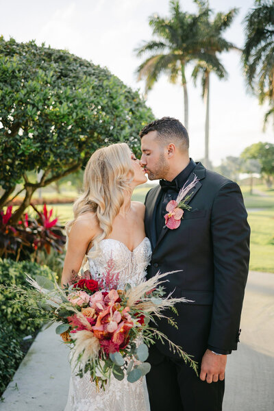 Bride and Groom kissing near the Golf course at the Boca Raton Resort in Boca Raton, Florida. Photo by Maggie Alvarez Photography