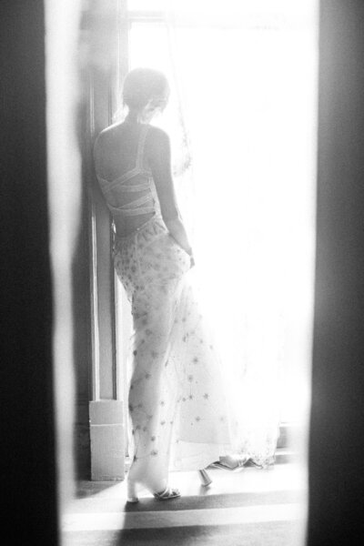 bride looking out the window before the first look.