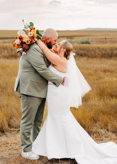Western Montana bride and groom embracing in field in Choteau, MT