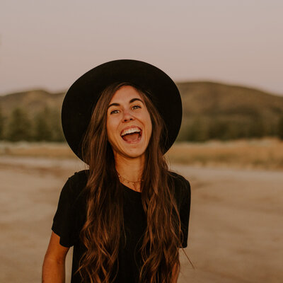 woman smiling and wearing a hat