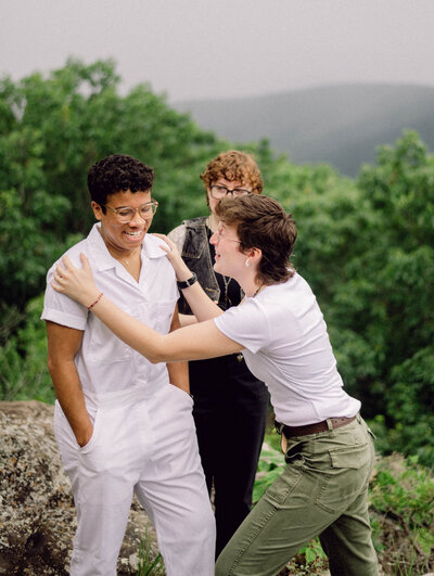 Cinematic wide shot of the couple embracing on the summit, with soft focus and natural light.

