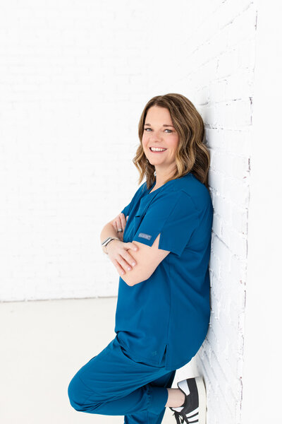 Meet the dedicated weight loss clinic professional standing in front of a white wall in her nurse uniform at Reforme Wellness.