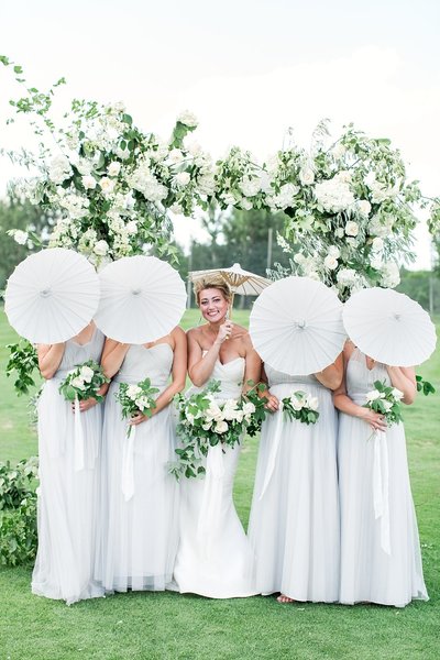 bride and bridesmaids posing with umbrellas