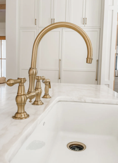 The bridge-style kitchen faucet is from Newport Brass and has a warm brass finish