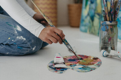 painter grabbing paint in her studio in Scottsdale