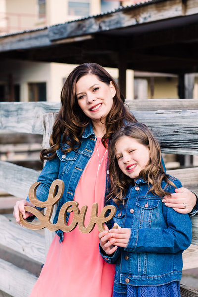 Mother and Daughter Holding Love Sign