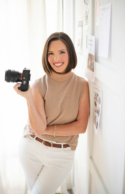 woman smiling and holding a camera