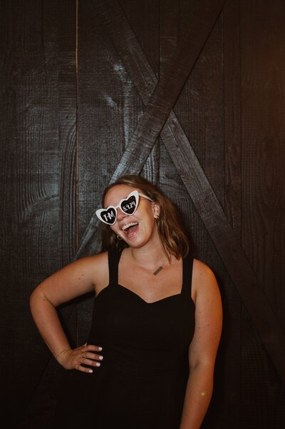 Rachel poses with fun glasses while at a wedding, representing her fun personality while working for Bubbly Bride Planning