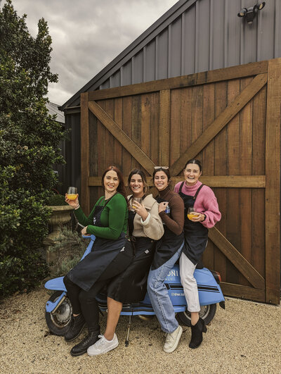 Four ladies smiling on Vespa