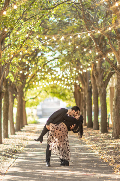 Couple kisses down a row of trees at the art museum in Rochester New York