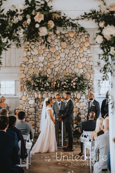 Elegant wedding ceremony setup featuring lush floral arrangements by Leigh Florist, with vibrant roses, greenery, and aisle decor under a romantic outdoor setting.