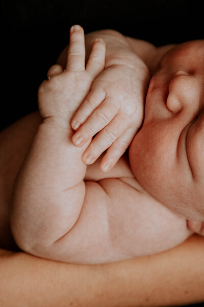 la petite main d'un bébé sur l'épaule de sa maman