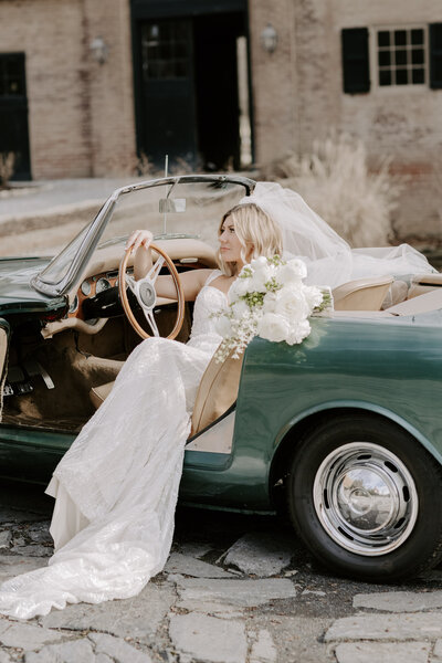 Bride sitting in vintage car at Conestoga house,  Lancaster PA wedding