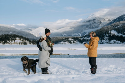 Whistler groom bends down to pet dog after Whistler wedding ceremony