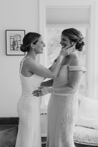 bride embracing mother while getting ready