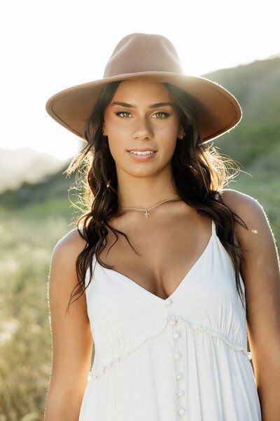 teen girl with sunflare and dramatic expression looking confident for her senior portraits at golden hour in Los Angeles 