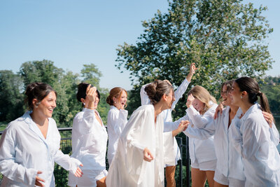 A bride and her bridesmaids dance together the morning of her wedding day.