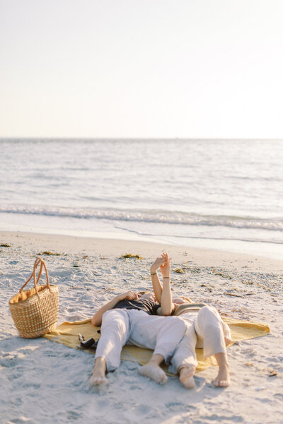 Couple poses for engagement pictures on the beach