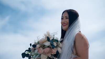 bride holding bridal bouquet while smiling