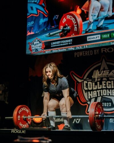 collegiate national US power lifter beginning a dead lift on stage at the national competition