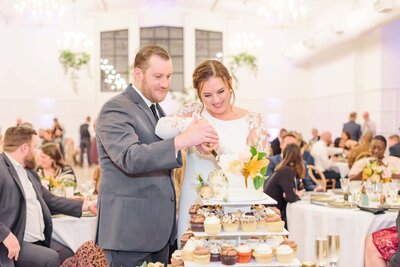 The couple cuts their wedding cake during their reception at the Distillery in Garner, NC.