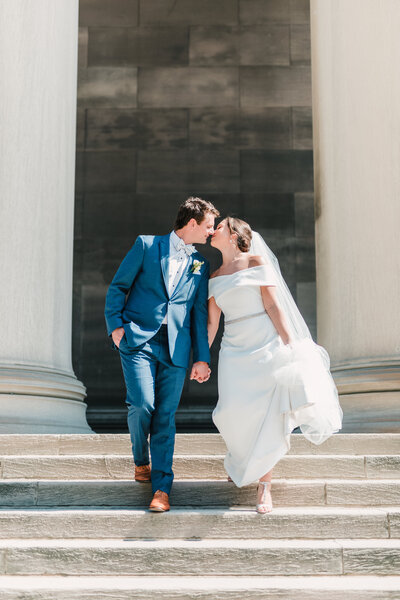 Bride and groom kissing on the steps of The Columns in Pittsburgh, captured by Amber Marie, a Pittsburgh wedding photographer.