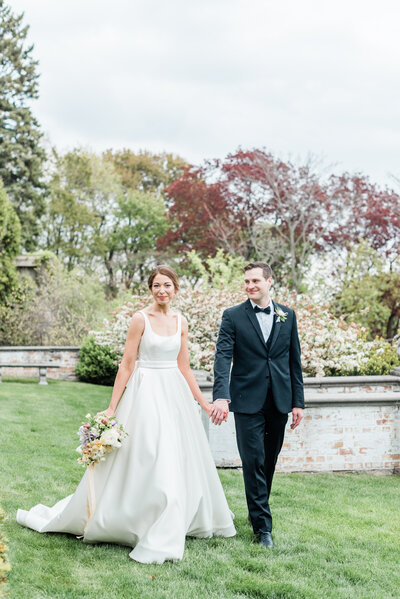 bride and groom walking in the back of villa terrace decorative arts museum on their wedding day