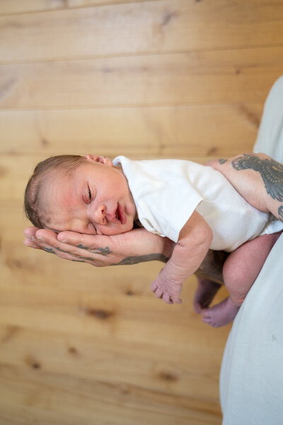 A newborn being held by dad.