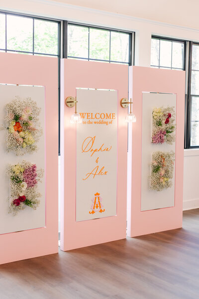Pink custom wedding welcome sign build featuring floral panels and a monogram, handcrafted by Cove Mill Design Co. for a romantic New England celebration.