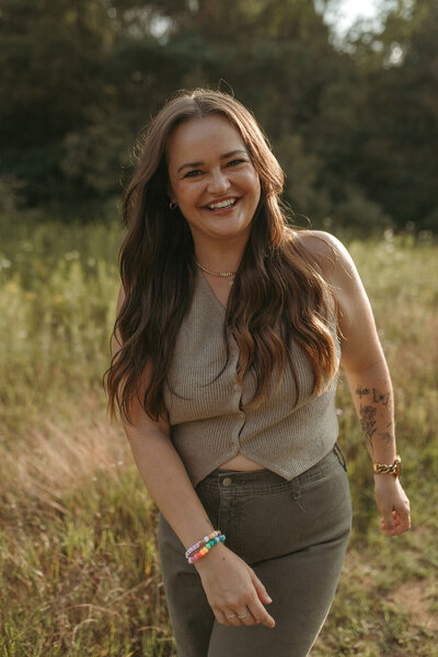 Portrait of Paige Rini, Michigan wedding photographer, standing in a field
