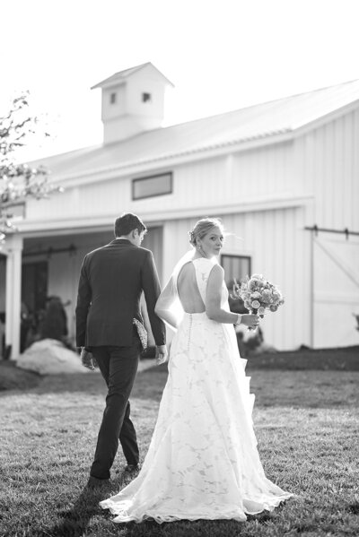 Bride looks over her shoulder while walking with her groom