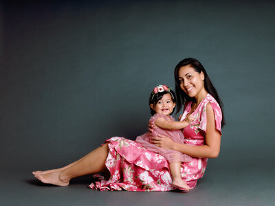 Maman et sa fille, portrait studio en robe rose, sur fond noir, lumière latérale