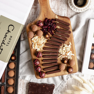 assorted chocolates and nuts arranged on a wooden board